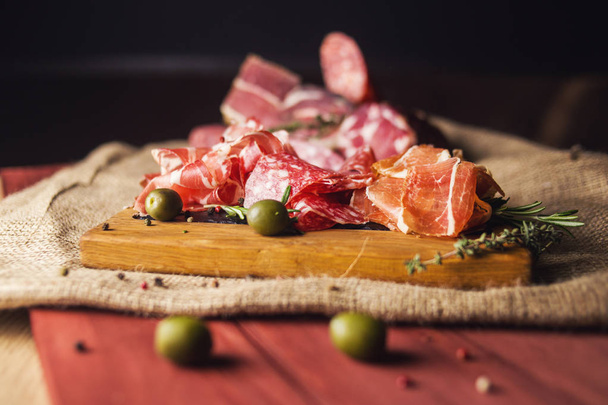 set with ham,sausage and fresh rosemary isolated on wooden - Фото, зображення