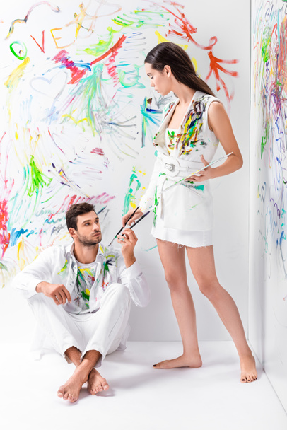 couple in painted white clothes with drawing equipment - Φωτογραφία, εικόνα