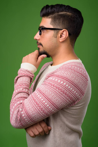 Young bearded Iranian man against green background - Фото, зображення