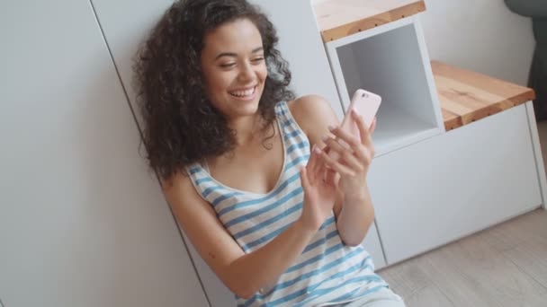Charmante jeune femme brune utilisant le téléphone dans un appartement élégant moderne
. - Séquence, vidéo