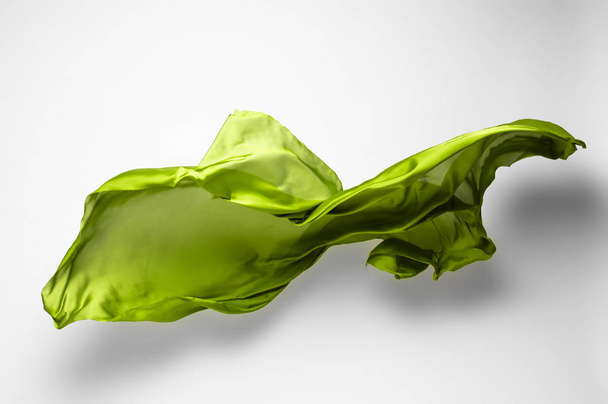 astratto pezzo di tessuto verde volante, ad alta velocità colpo in studio - Foto, immagini