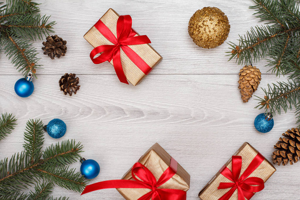 クリスマス装飾。ギフト用の箱、コーン、灰色板のクリスマスのおもちゃとモミの木の枝します。平面図です。クリスマスのグリーティング カードの概念. - 写真・画像