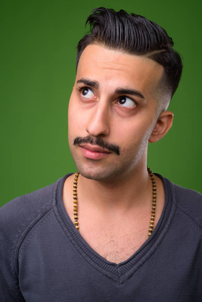 Joven hombre iraní guapo con bigote contra fondo verde
 - Foto, imagen
