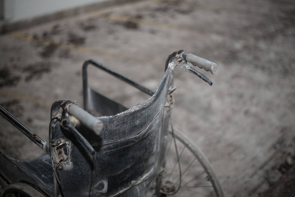Close-up van oude rolstoel in donkere Toon. - Foto, afbeelding