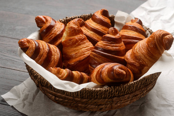 Wicker basket of fresh croissants - Foto, afbeelding