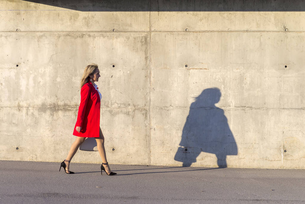 Businesswoman woman wearing red jacket walking on the street - Foto, afbeelding