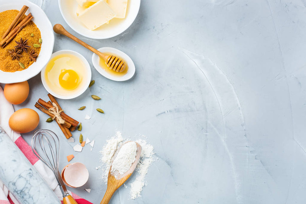 Cozinhar ingredientes e utensílios de cozinha em uma mesa de cozinha. Farinha, açúcar, manteiga, ovos, especiarias, mel. Topo vista plana leigos cópia espaço fundo
 - Foto, Imagem