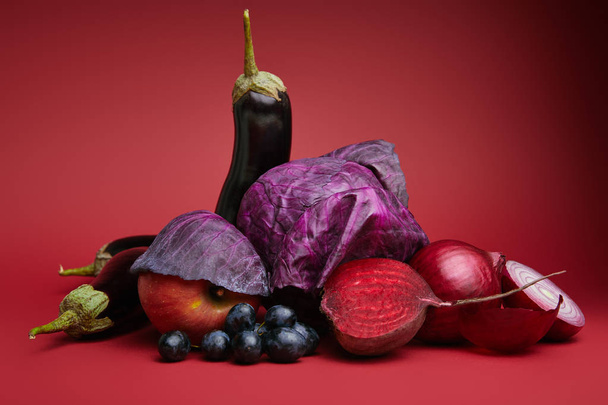 vergrote weergave van verse rijpe vruchten en groenten op rood - Foto, afbeelding