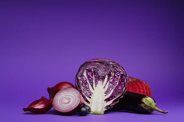 sliced cabbage, onions, grapes, beetroot and eggplant on purple - Fotó, kép