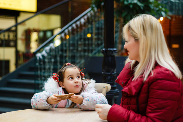 Noel dekore kafede küçük kızı ile genç anne - Fotoğraf, Görsel