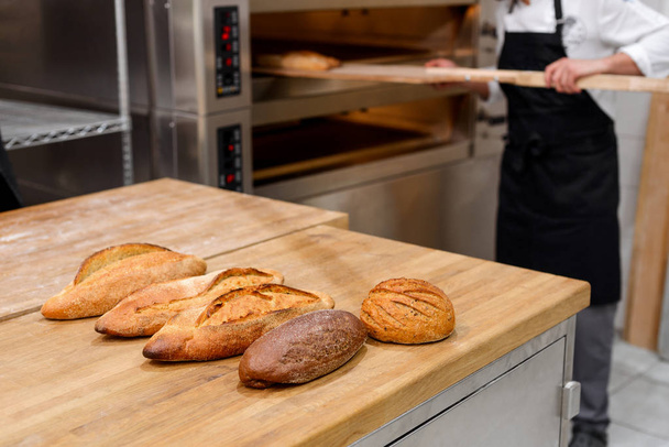 Taking baked bread out - Foto, imagen