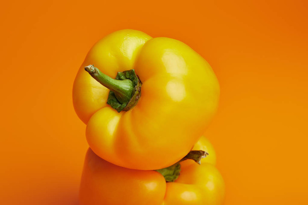 close-up view of fresh ripe bell peppers on orange - Foto, Imagem