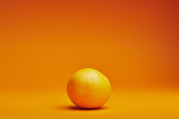 vergrote weergave van verse rijpe hele oranje over oranje achtergrond  - Foto, afbeelding
