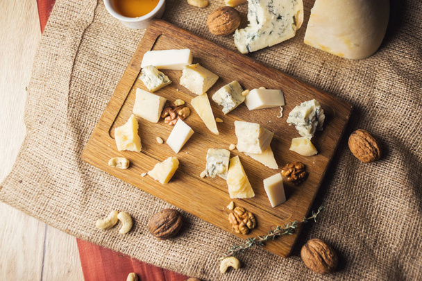 cheese plate with honey, and nuts isolated on wooden - Φωτογραφία, εικόνα
