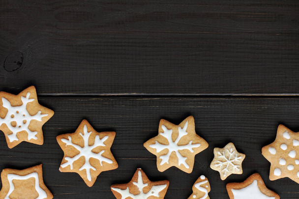 flat layout of the cookies in the form of stars and snowflakes on dark wooden surface top view / delicious festive Starfall - Foto, immagini