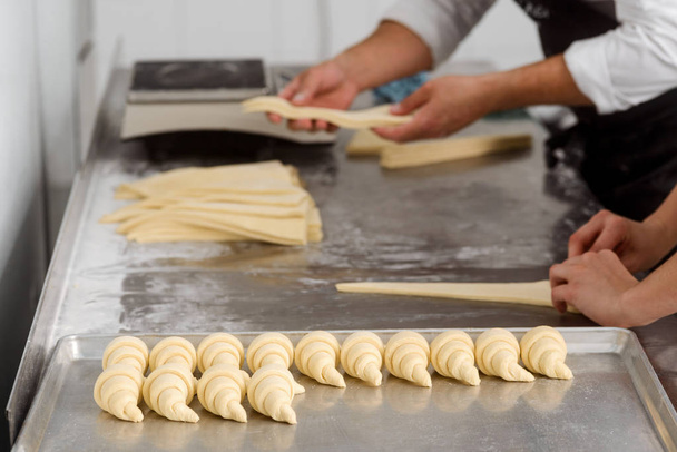 Bakery workers making crescent rolls - Фото, изображение