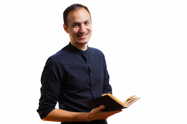 Beyaz arka planda kutsal İncil tutan siyah gömlekli adam  - Fotoğraf, Görsel