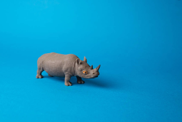 close up view of toy rhino on blue background  - Foto, Bild