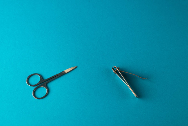 flat lay with nail scissors and nail clippers for personal hygiene on blue background - Zdjęcie, obraz