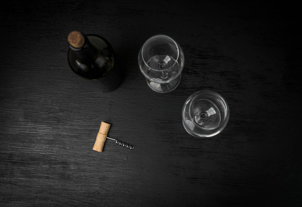 bottle of wine and two empty glasses on black background - Foto, immagini