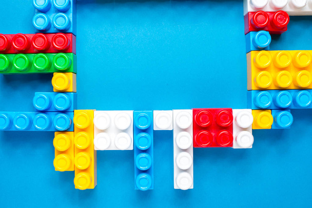 Frame of colorful toy bricks on  construction plate - Photo, image