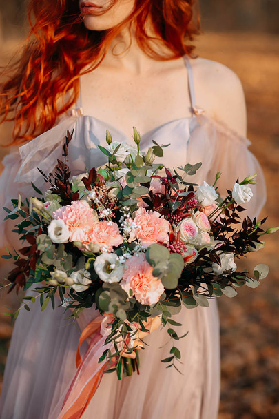Redhead girl with freckles holding a wedding bouquet - Photo, Image