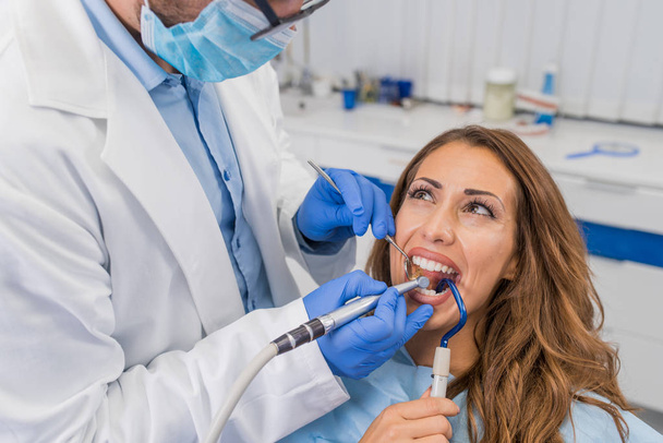 Dentiste masculin travaillant avec une jeune femme
 - Photo, image