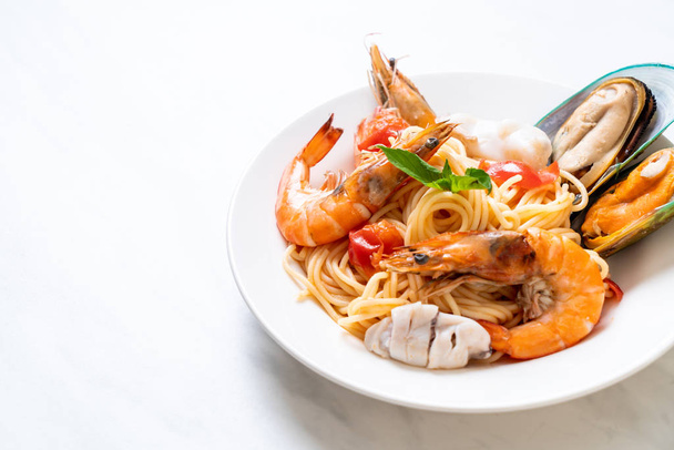 Seafood pasta Spaghetti with Clams, Prawns, Squis, Mussel and Tomatoes - Italian food style - 写真・画像