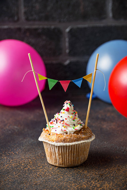Birthday cupcake with cream and colorful garland  - Photo, Image
