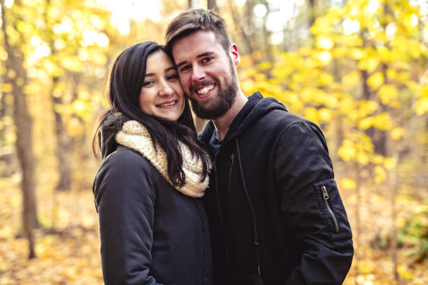 秋の公園で楽しみを持っている若いカップル - 写真・画像
