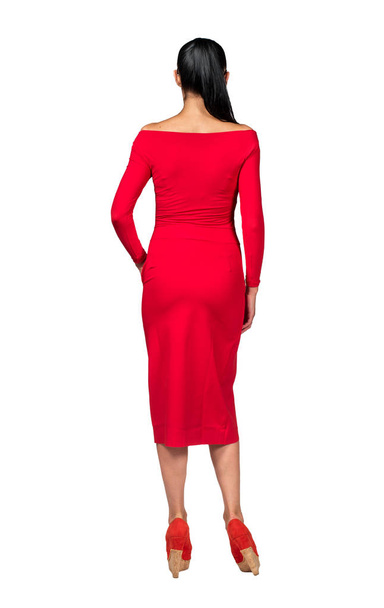 Modelo en vestido corto rojo sobre fondo blanco, vista trasera
 - Foto, Imagen