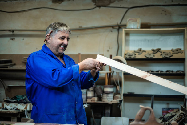 Carpenter at work in his workshop, a man makes measurements - 写真・画像