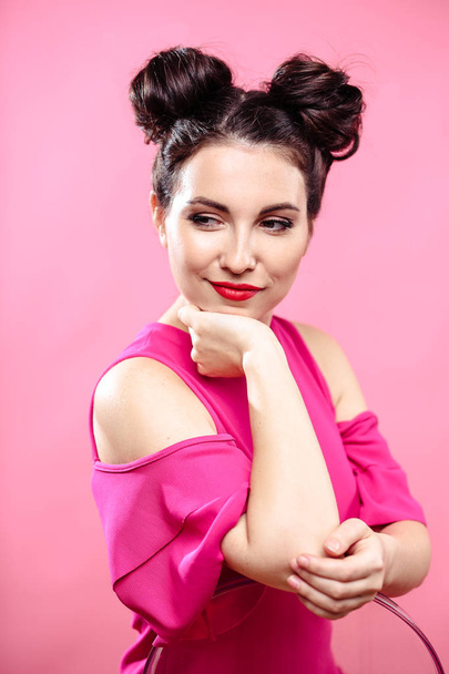 Beauty portrait of young brunette woman on a bright pink background. Model with make-up and hairstyle, closeup, fashion glamour photo - Foto, Imagen
