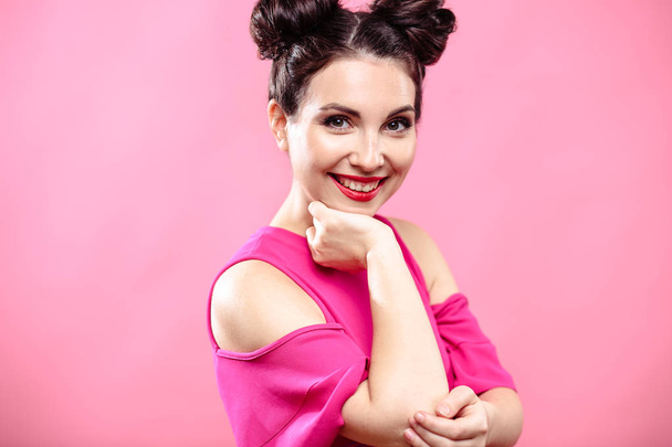 Beauty portrait of young brunette woman on a bright pink background. Model with make-up and hairstyle, closeup, fashion glamour photo - Valokuva, kuva
