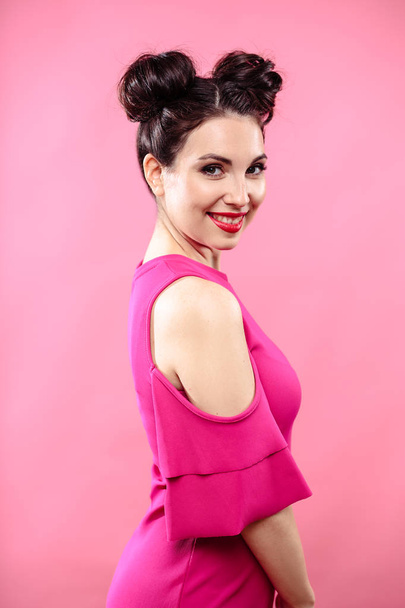 Beauty portrait of young brunette woman on a bright pink background. Model with make-up and hairstyle, closeup, fashion glamour photo - Φωτογραφία, εικόνα