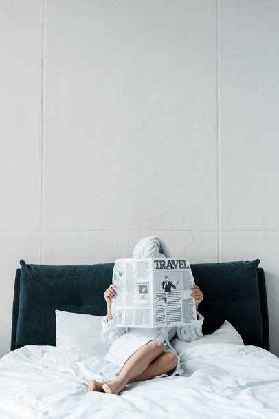 Kobieta czytająca gazetę podróży na łóżko rano  - Zdjęcie, obraz