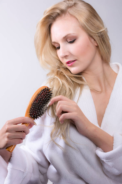 young blonde woman brushes her hair - Photo, Image