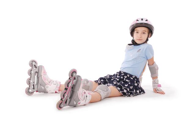 Happy little girl with roller skates and protective gear resting - isolated on white background - Fotoğraf, Görsel