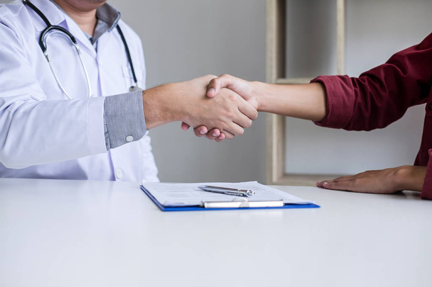 Professional Male doctor in white coat shaking hand with female patient after successful recommend treatment methods, Medicine and health care concept. - Photo, image