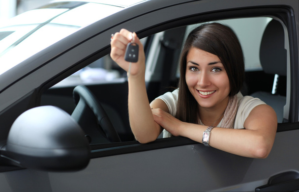 Happy smiling woman with car key. Driving - Zdjęcie, obraz