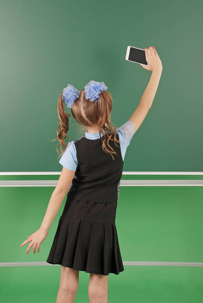 Cute girl schoolgirl near blackboard the concept of education and school life - Photo, Image