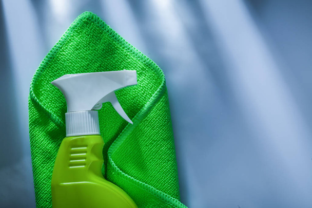 Green washing rag sprayer on white surface. - Фото, изображение