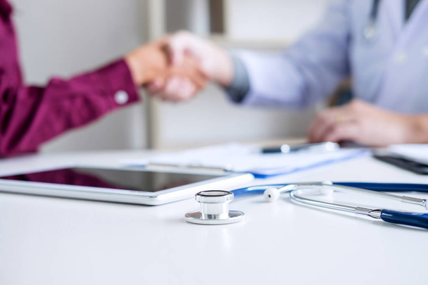 Professional Male doctor in white coat shaking hand with female patient after successful recommend treatment methods, Medicine and health care concept. - Photo, Image