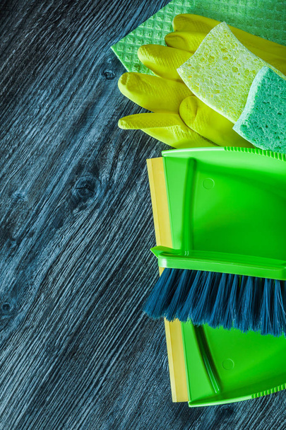 Dustpan broom sponges safety gloves washcloth on wooden board. - Fotó, kép
