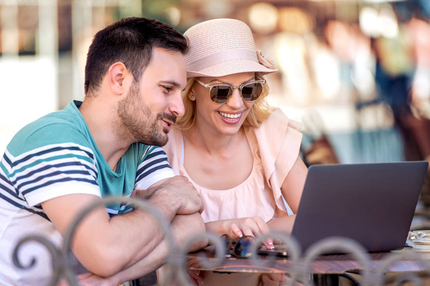 férias de verão, cidade, namoro e conceito de tecnologia. Retrato de jovem casal feliz com laptop no café
. - Foto, Imagem