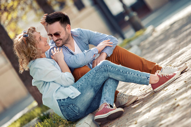 Sorrindo lindo jovem casal conversando e sentado ao ar livre
. - Foto, Imagem