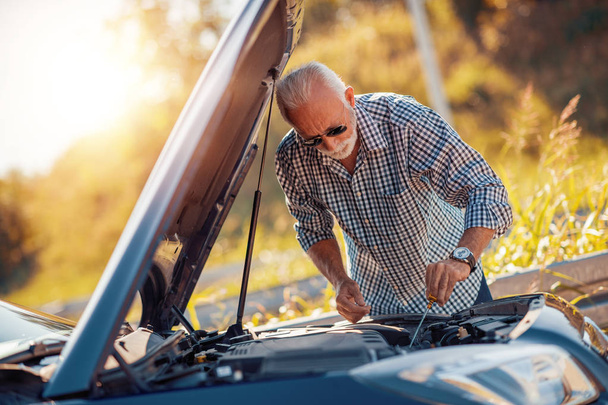 Senior man checking oil level in car. - Photo, Image