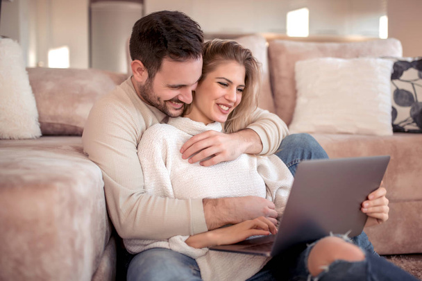 Casal jovem relaxante no sofá com laptop.Love, felicidade, pessoas e conceito divertido
. - Foto, Imagem