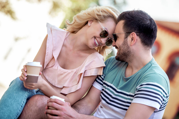 Happy loving couple.Cheerful young couple drink coffee to go and having fun outdoors. - Photo, Image