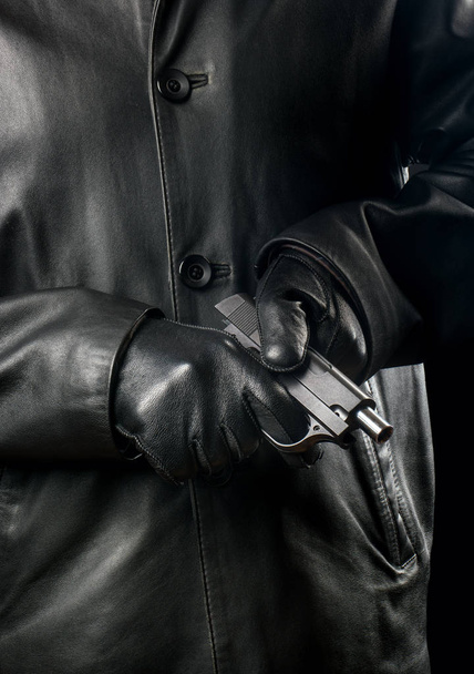 Bandita v černém oblečení a rukavice zbraň znovu načte - Fotografie, Obrázek
